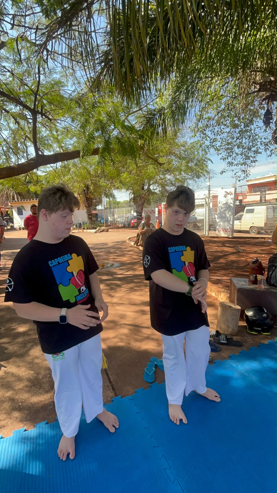 Dois participantes da Capoeira Inclusiva em uma atividade ao ar livre
