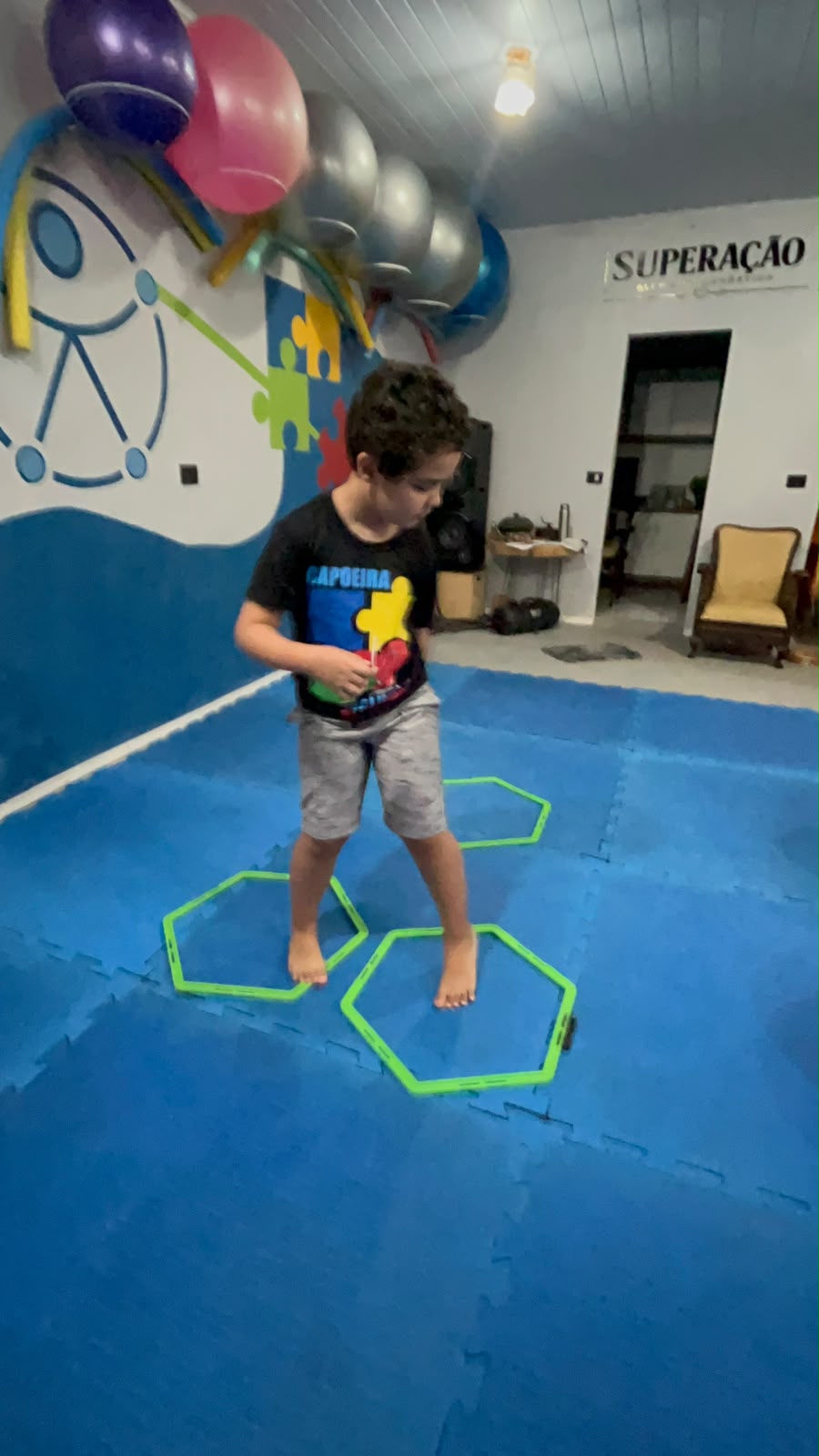 Criança realizando um percurso de coordenação motora com marcações coloridas